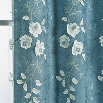 Modrý závěs s bílou květinovou výšivkou