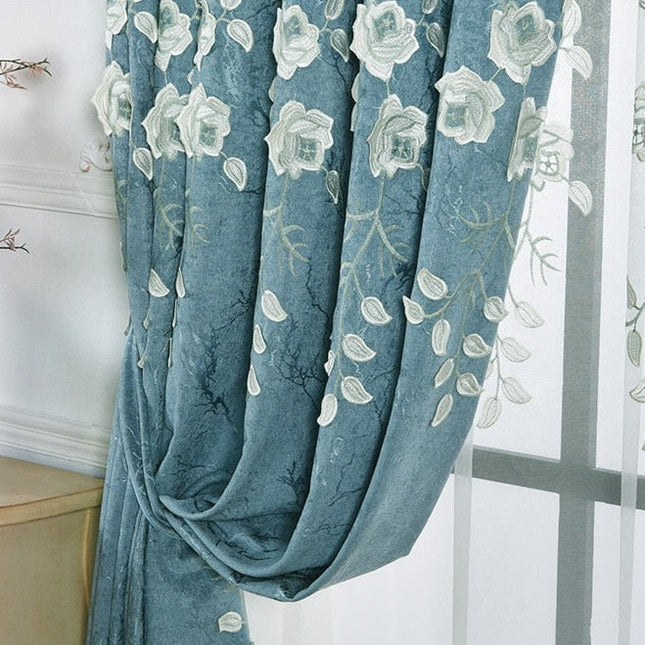 Modrý závěs s bílou květinovou výšivkou